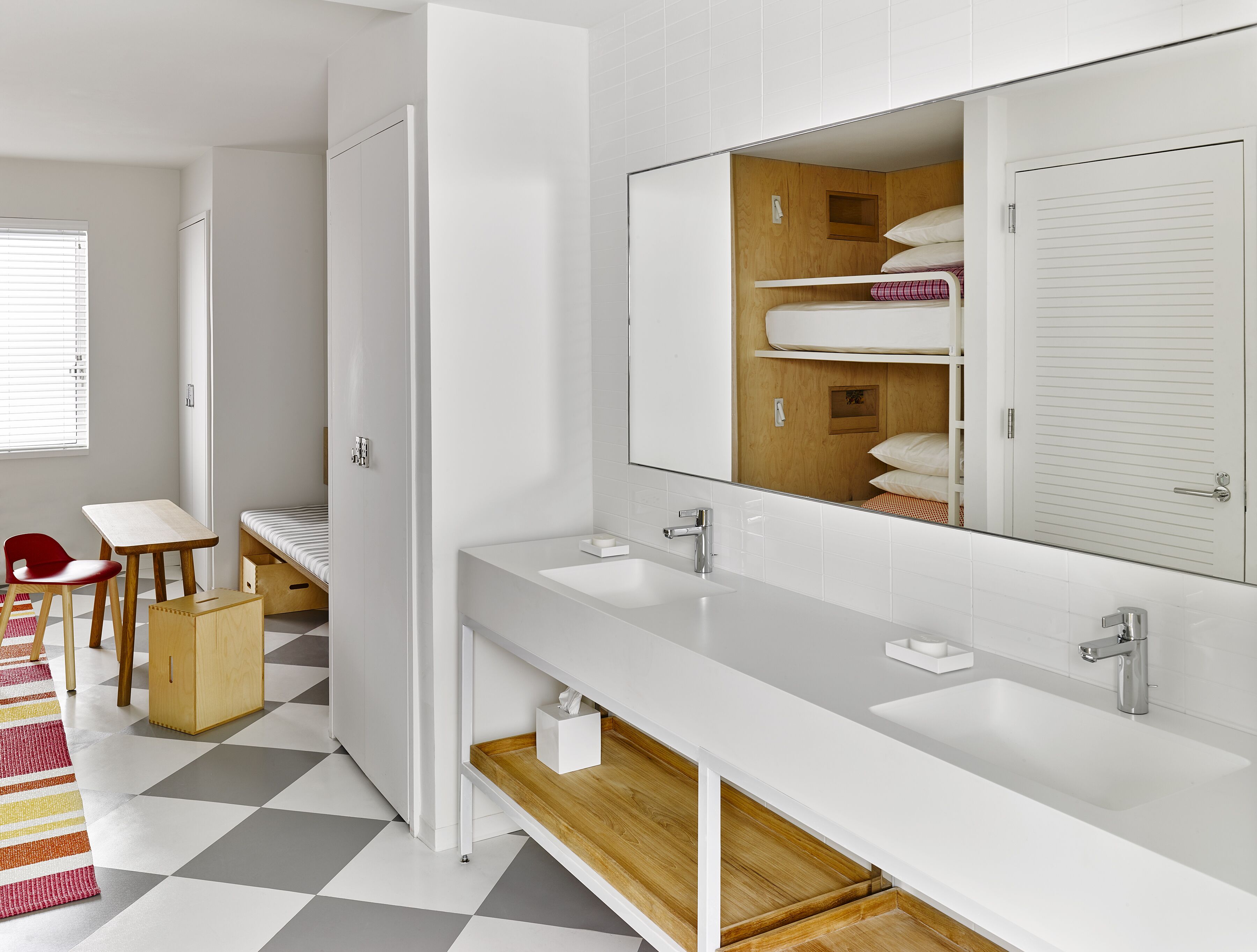 Une salle de bain moderne avec un grand miroir, deux vasques et un meuble-lavabo en bois.