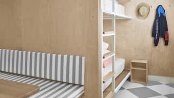 Una habitación con un banco a rayas, un armario de madera, un estante blanco y un suelo de cuadros.