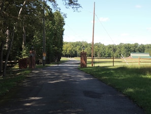 A gated entrance to a property with a paved path leading through it.