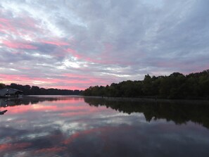 A calm lake with a dock and a small building, surrounded by trees. - MV GiaMaria (Richmond)