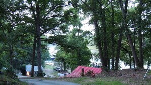 A narrow road flanked by trees leading to a red-roofed building. - MV GiaMaria (Richmond)