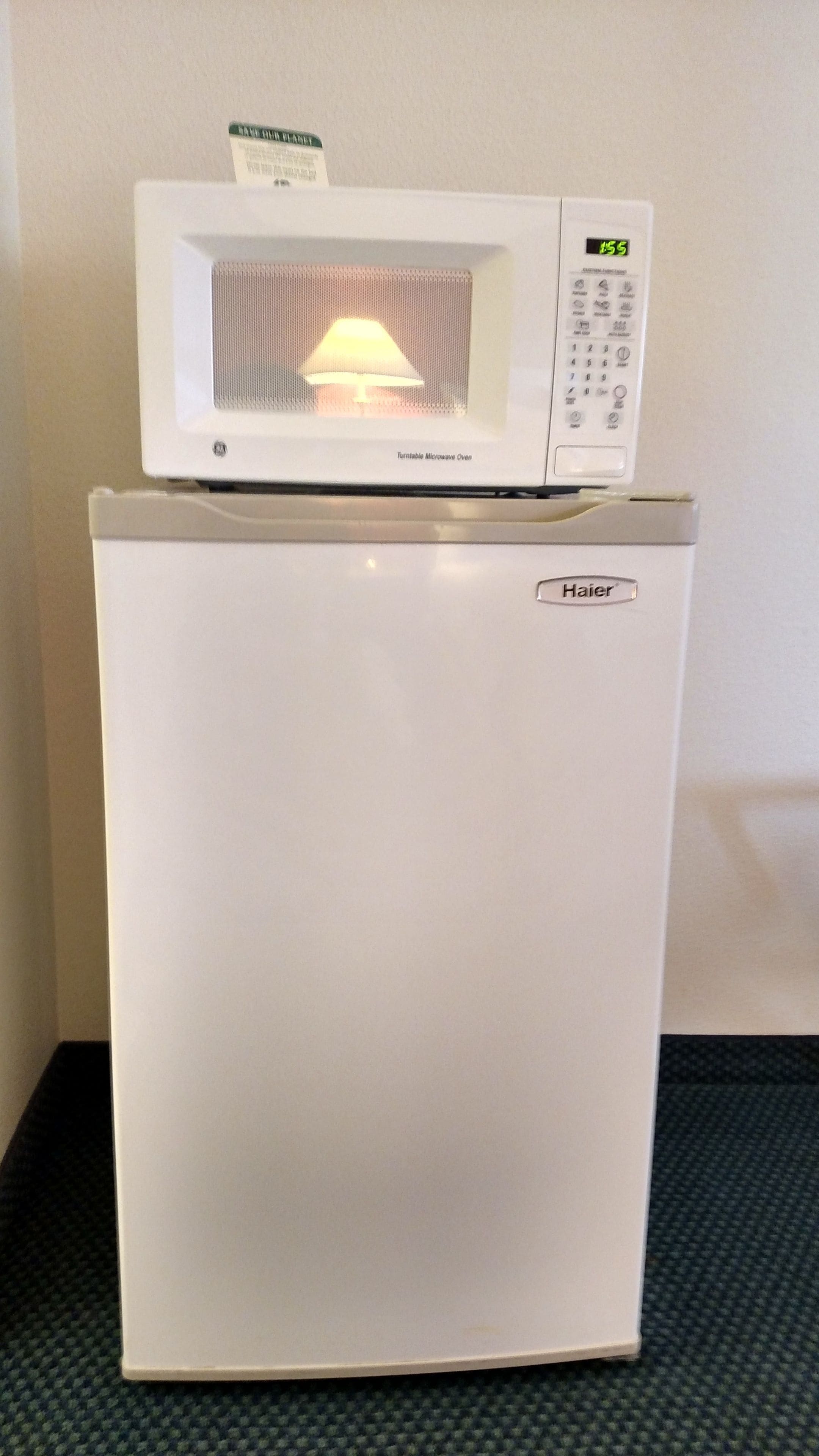 A white refrigerator with a microwave on top.