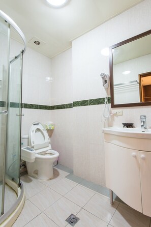 A bathroom with a shower, toilet, and sink.