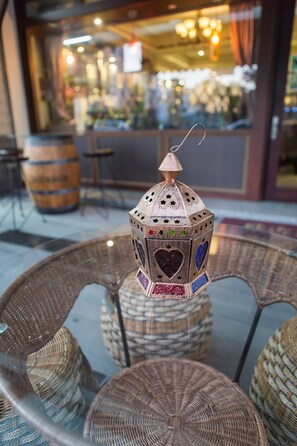A wicker chair with a decorative lantern in front.