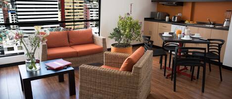 Una sala de estar moderna con muebles de mimbre, un comedor y una cocina.