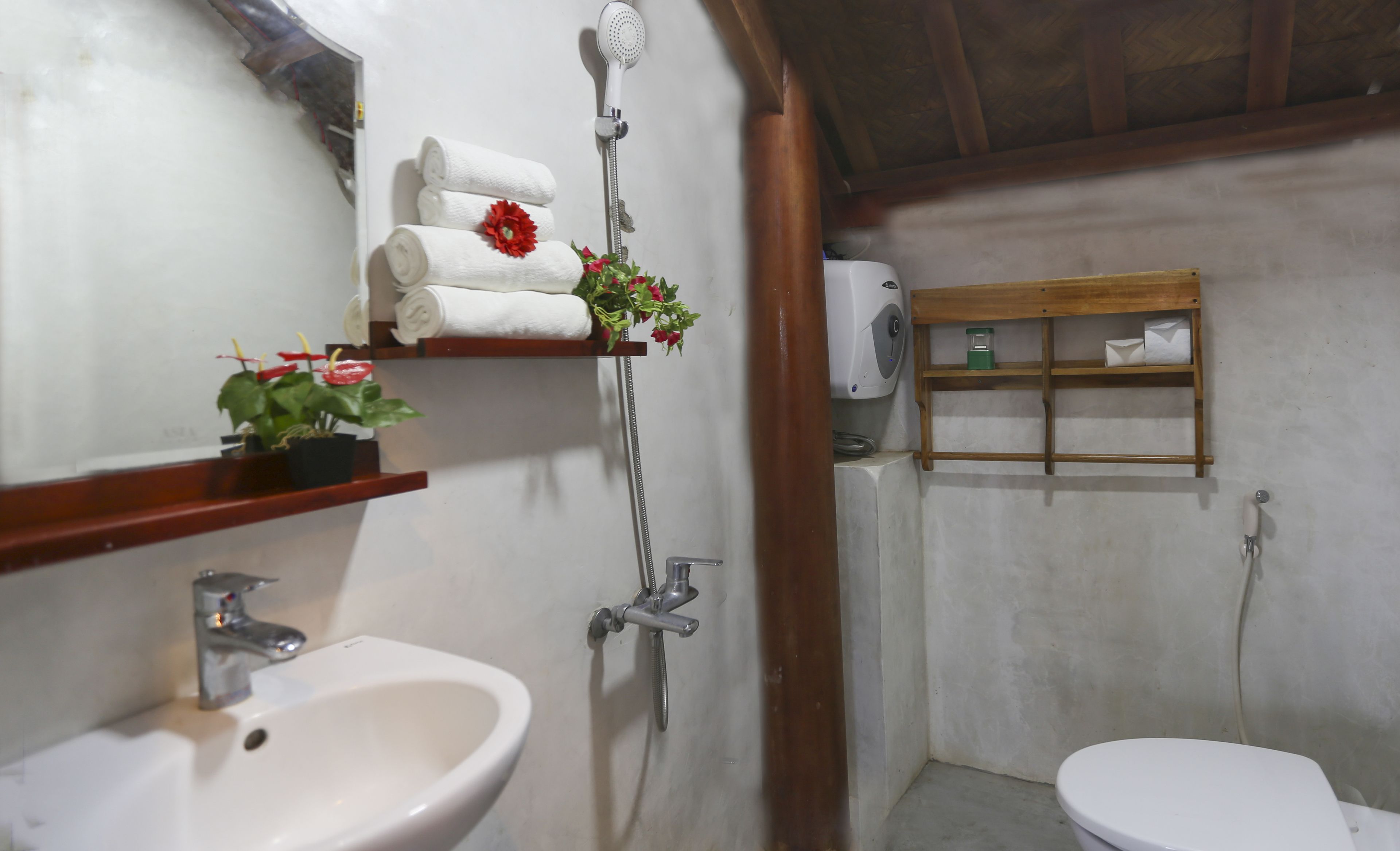 A bathroom with a sink, toilet, shower, and towel rack.