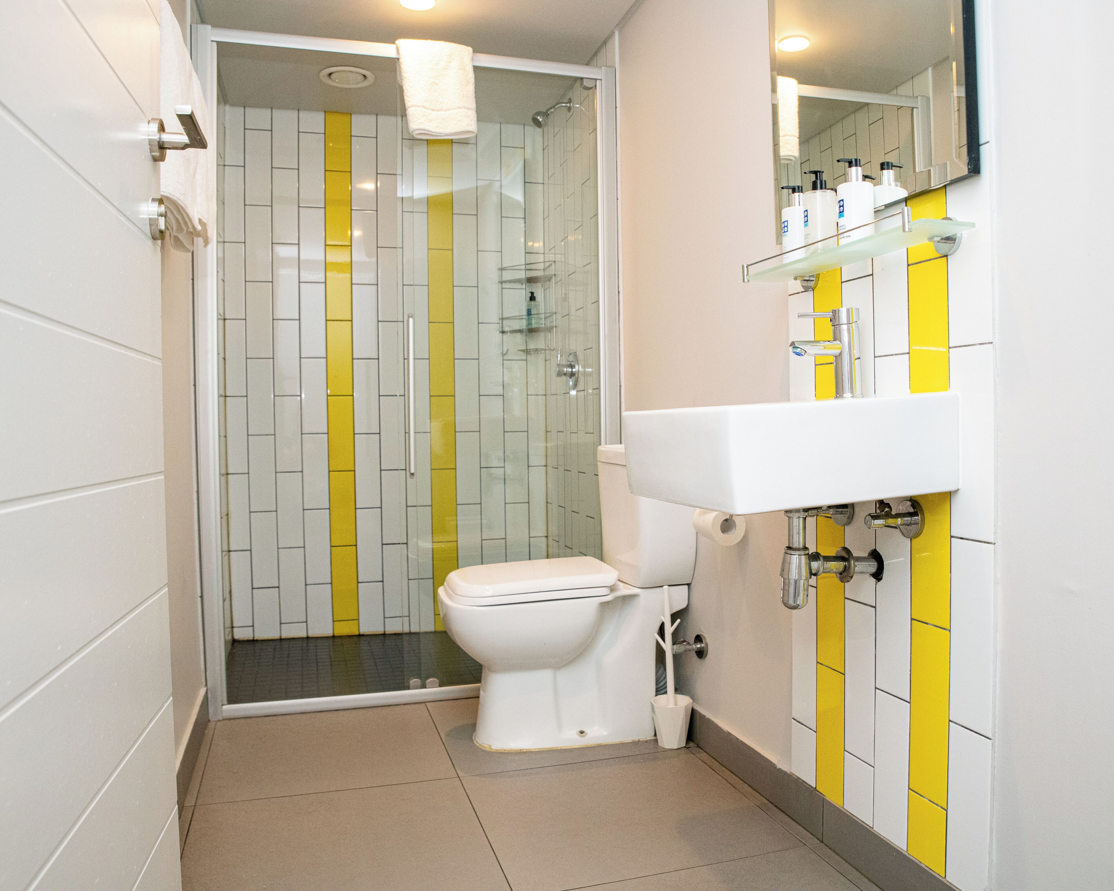A bathroom with a toilet, a shower, and a sink.