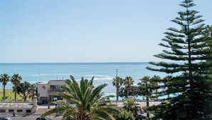 A coastal view with a building, palm trees, and the ocean. - Mojo Hotel (Cape Town)
