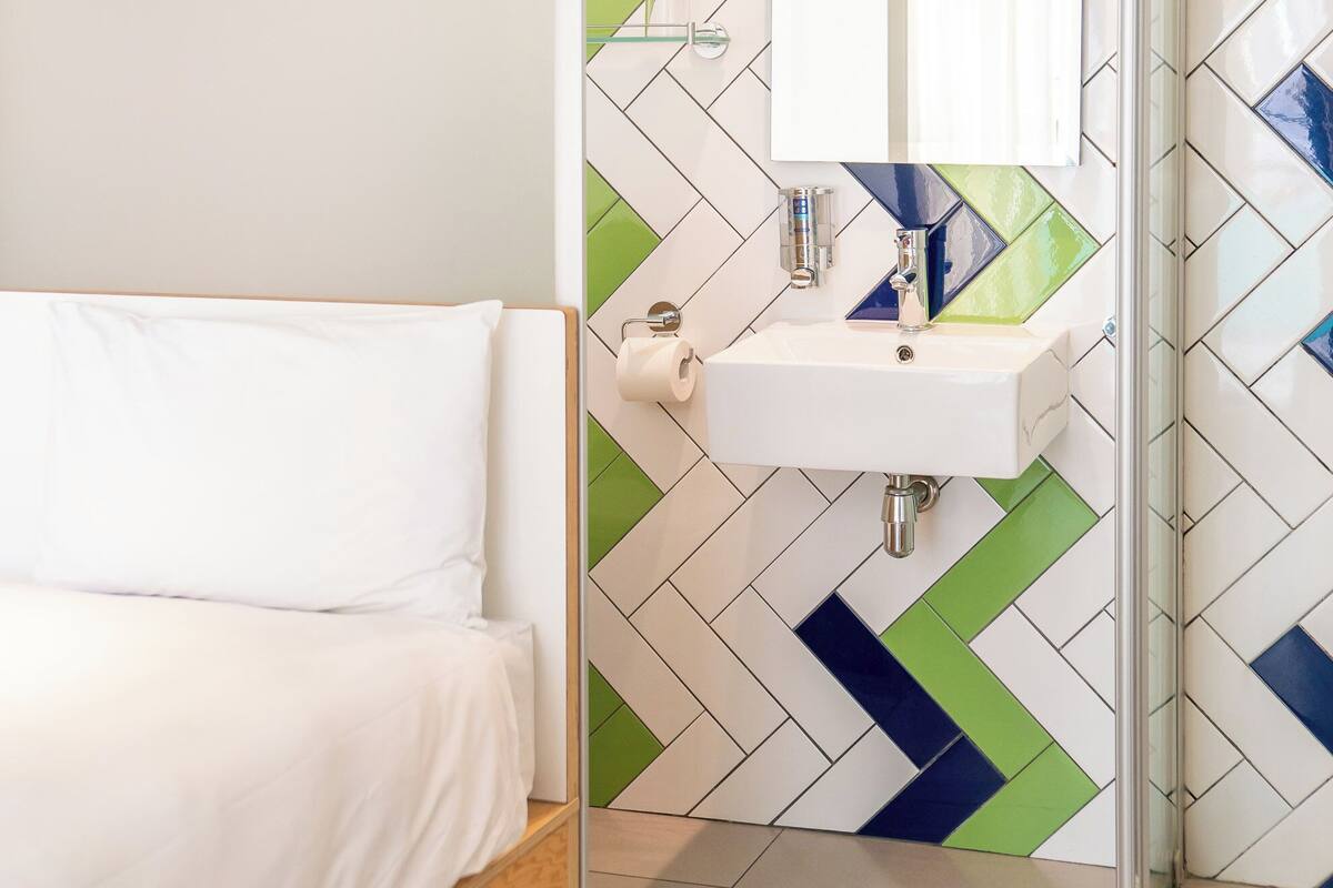 A modern bathroom with a shower, a sink, and a mirror.