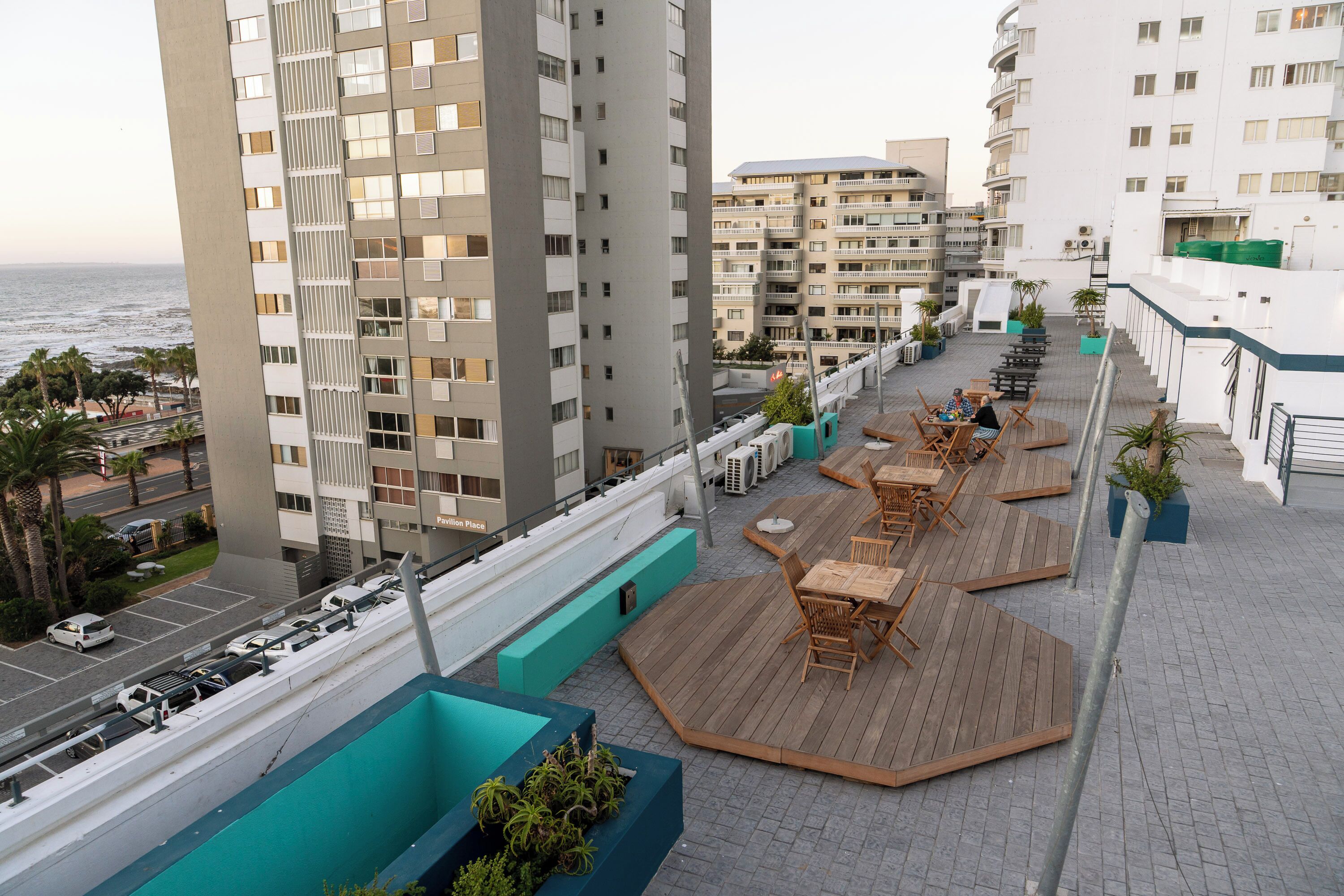 A rooftop terrace with outdoor seating and a view of the sea.