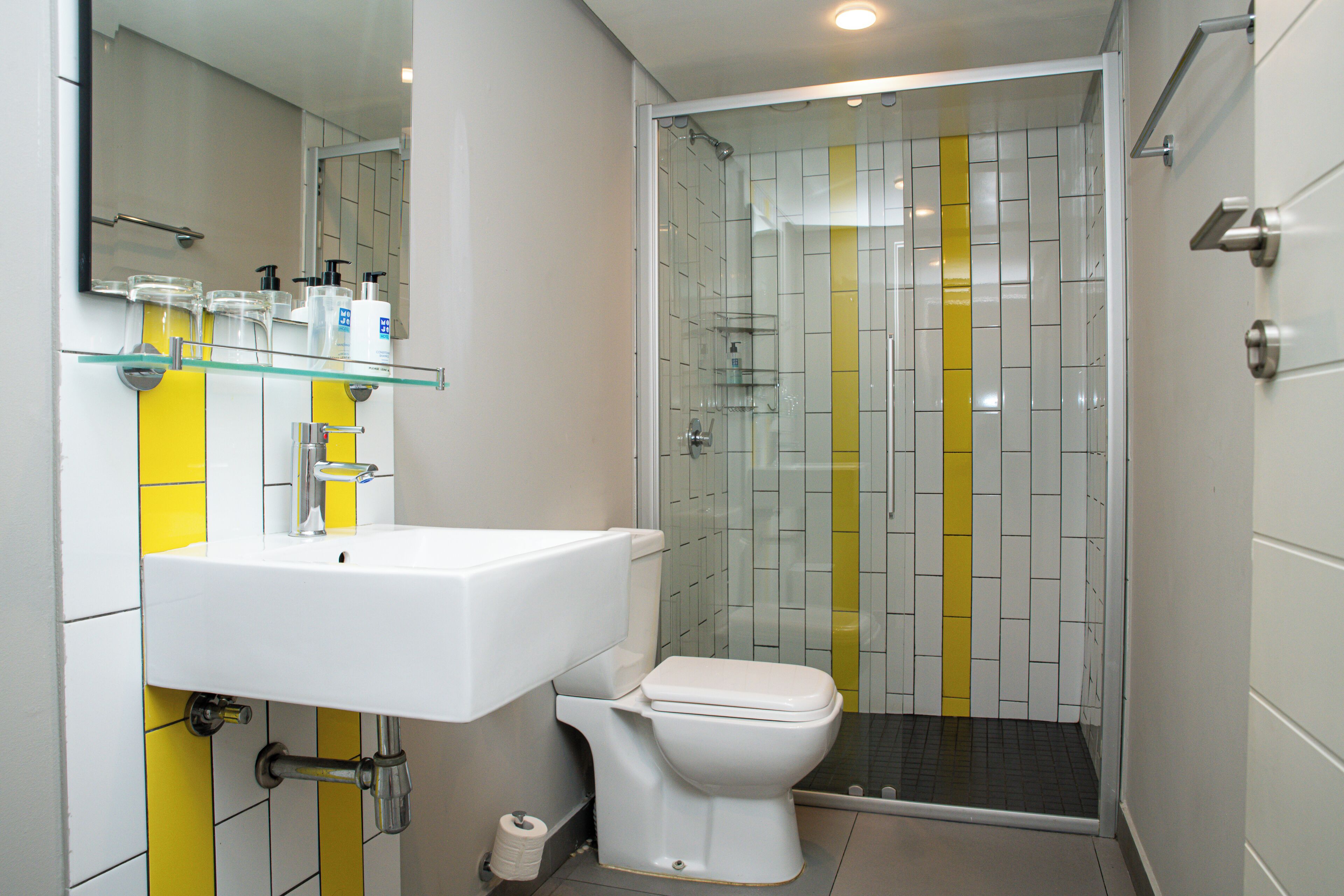 A bathroom with a white sink, toilet, and glass-enclosed shower.
