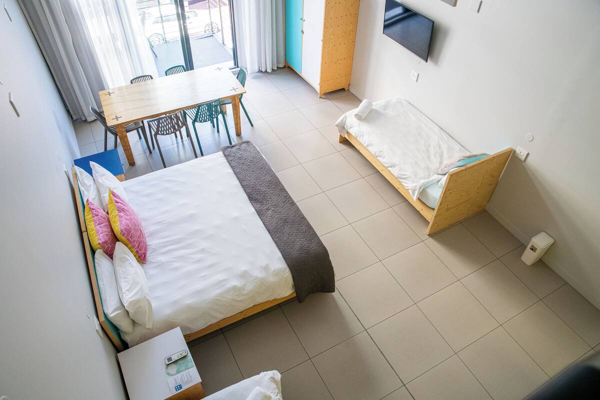 A room with a bed, a desk, and a small seating area.
