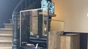 Una escalera de diseño moderno, un mostrador de recepción de madera y un televisor montado en la pared.
