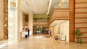 A spacious lobby with a reception desk, a luggage cart, and a seating area. - Jasmine Palace Hotel (Yangon)