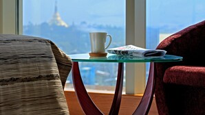 A room with a glass table, a white mug, and a newspaper. - Jasmine Palace Hotel (Yangon)