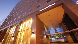 A modern hotel entrance with a glass facade and a sign reading "Richmond Hotel".