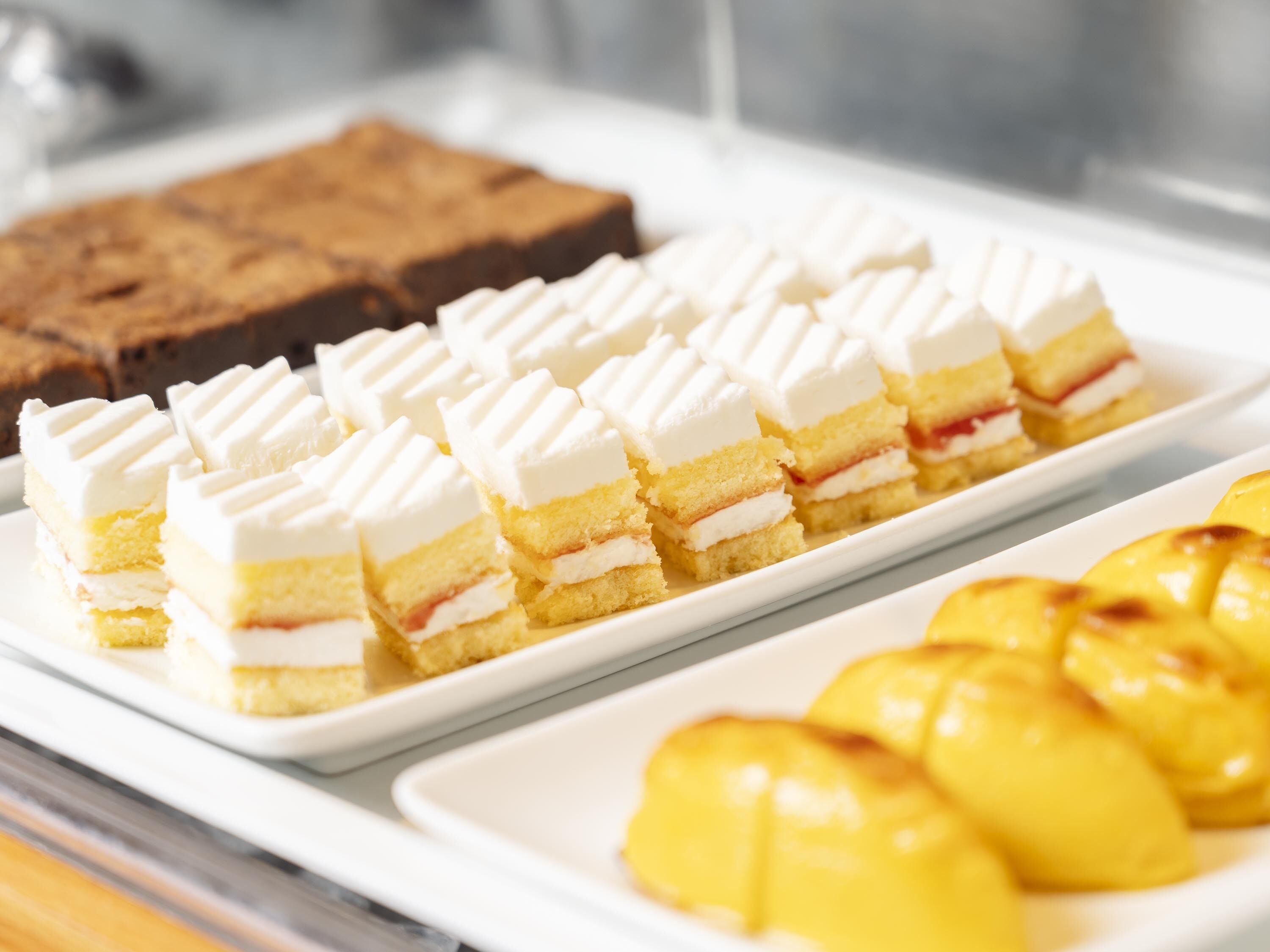 En bakke med desserter, herunder lagkager og frugttærter.