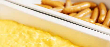 A buffet with scrambled eggs and French fries.