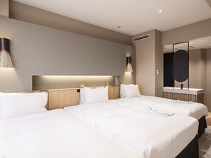 Habitación de hotel con dos camas, una mesita de noche, un espejo y una lámpara de pared.