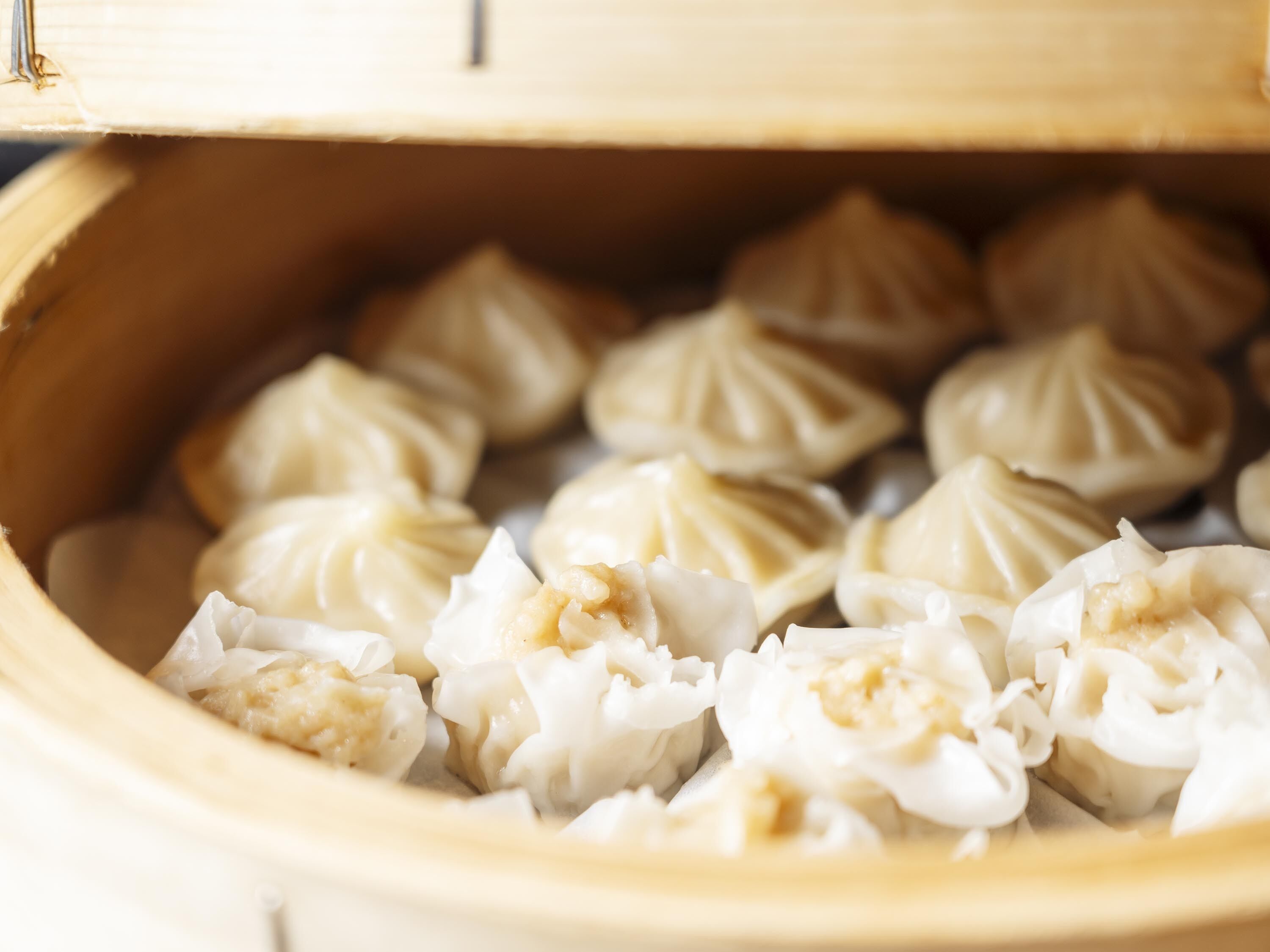 En närbild på en ångkorg fylld med dumplings.