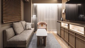 A modern living room with a sofa, a coffee table, a TV, and a cabinet.