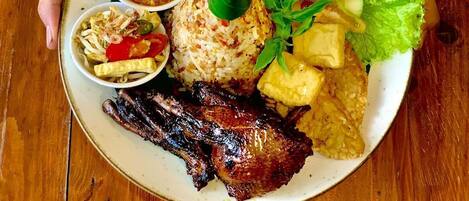 A plate of food with various dishes including rice, vegetables, and meat.