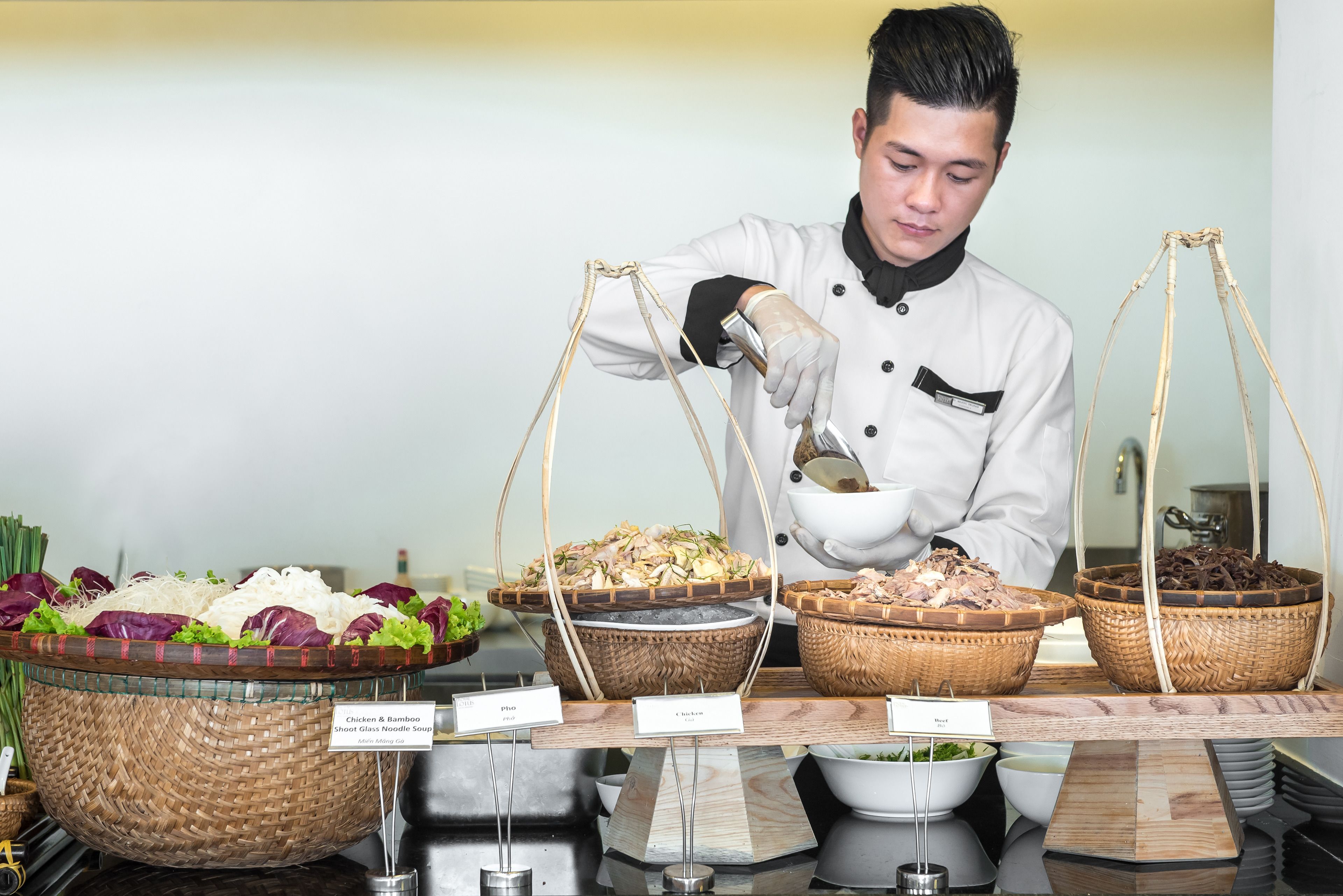 Un buffet proposant divers plats présentés dans des paniers et des bols, notamment des nouilles et des légumes.