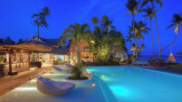 A resort with a swimming pool, lounge chairs, and a bar area. - Nay Palad Hideaway (General Luna)