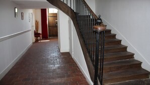 A wooden staircase with a metal balustrade leading to a room. - Château Latour (Fours)