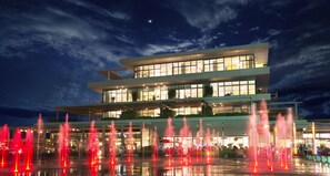 Un edificio moderno de varios pisos con una fuente decorativa en la fachada.