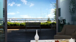 A balcony with a view of the sea, a white vase, and a table with breakfast items. - Atakoy Marina Park Hotel Residences (Istanbul)