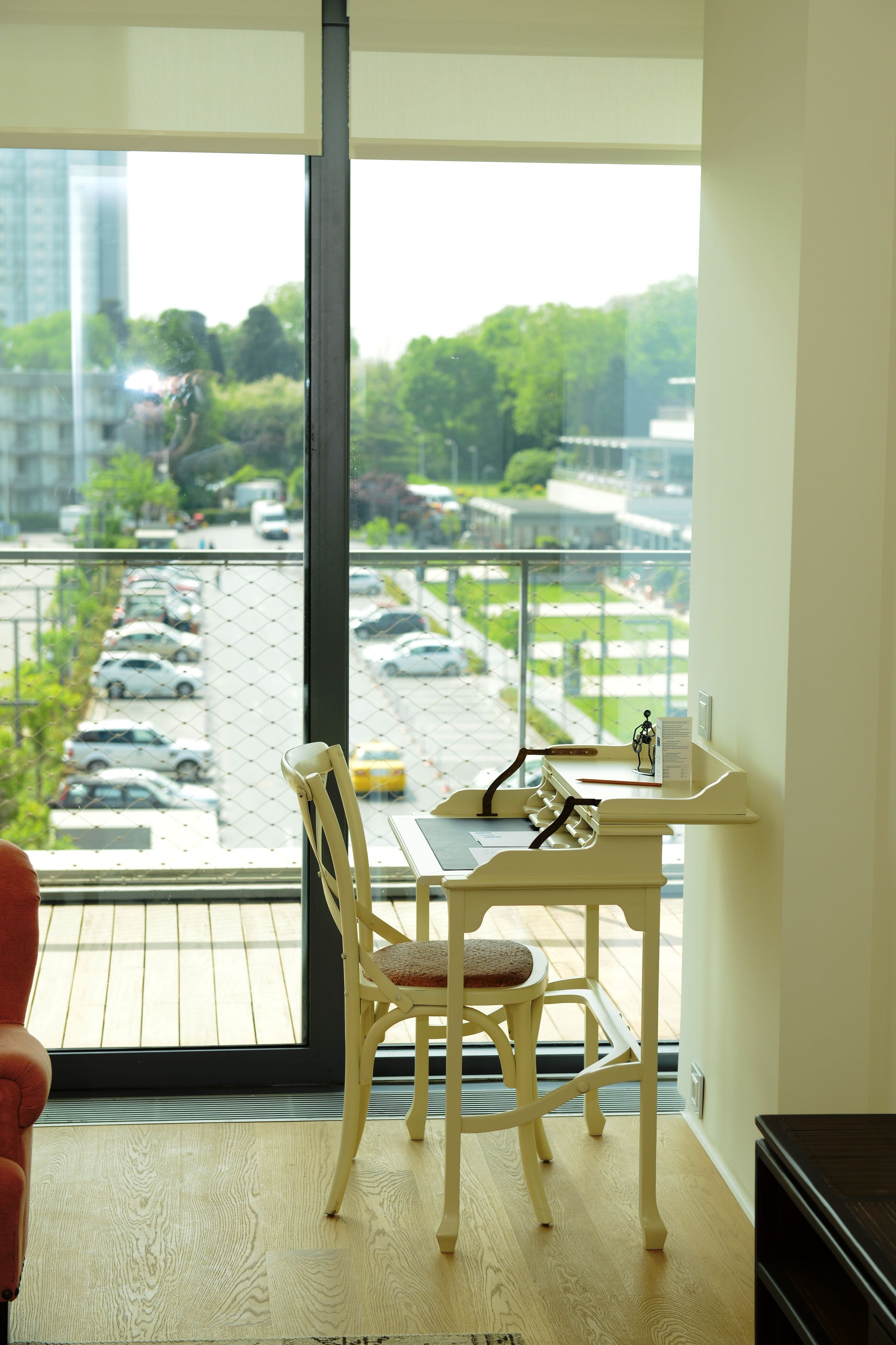 A room with a large window overlooking a parking area and greenery.