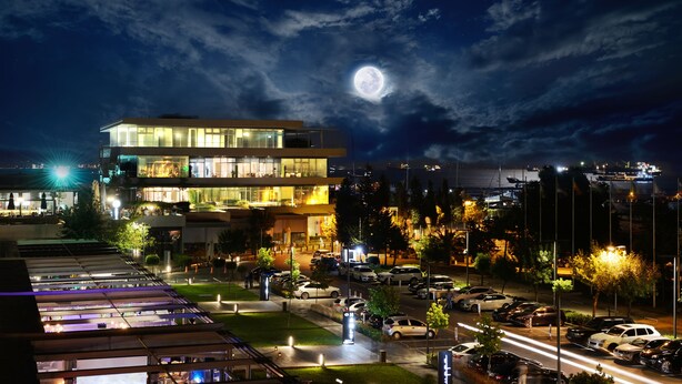 A modern hotel with a glass facade, a parking lot, and a view of the moon. - Atakoy Marina Park Hotel Residences (Istanbul)
