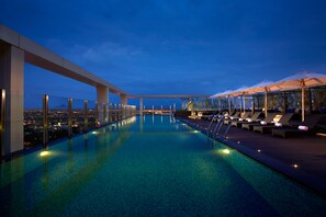 Una piscina al aire libre, sillones reclinables de piscina