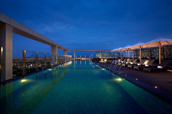 Una piscina al aire libre, sillones reclinables de piscina