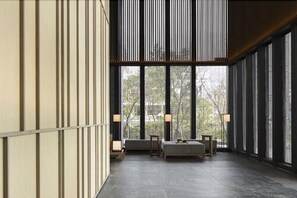 A spacious room with large windows, a sofa, two side tables, and a lamp. - Wellspring by Silks Jiao Xi (Jiaoxi)