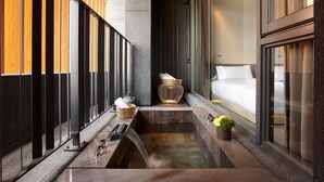 Een moderne badkamer met een inloopdouche, een klein wastafeltje en een grote spiegel.