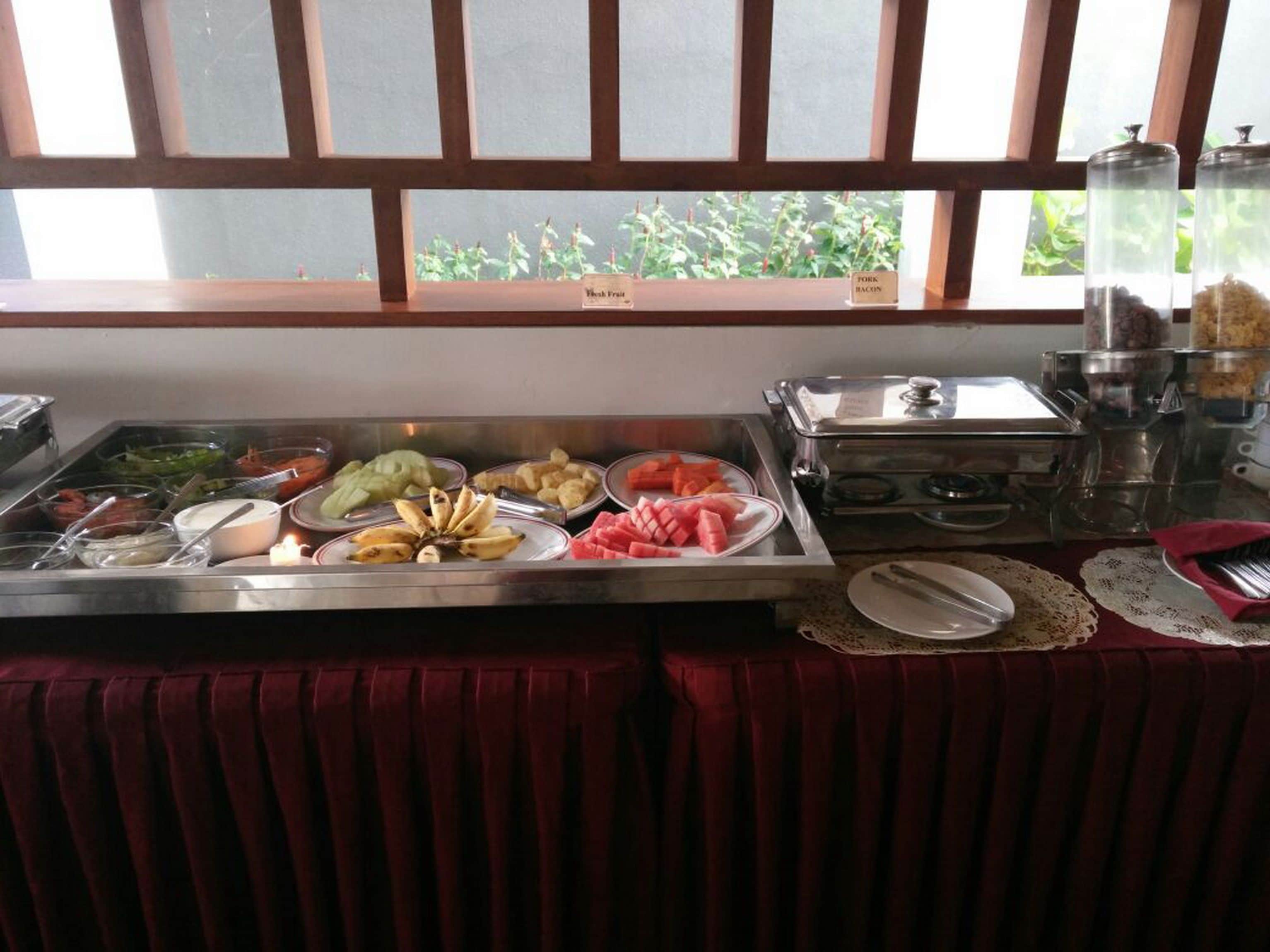 A buffet with various food items including fruits, vegetables, and meats.
