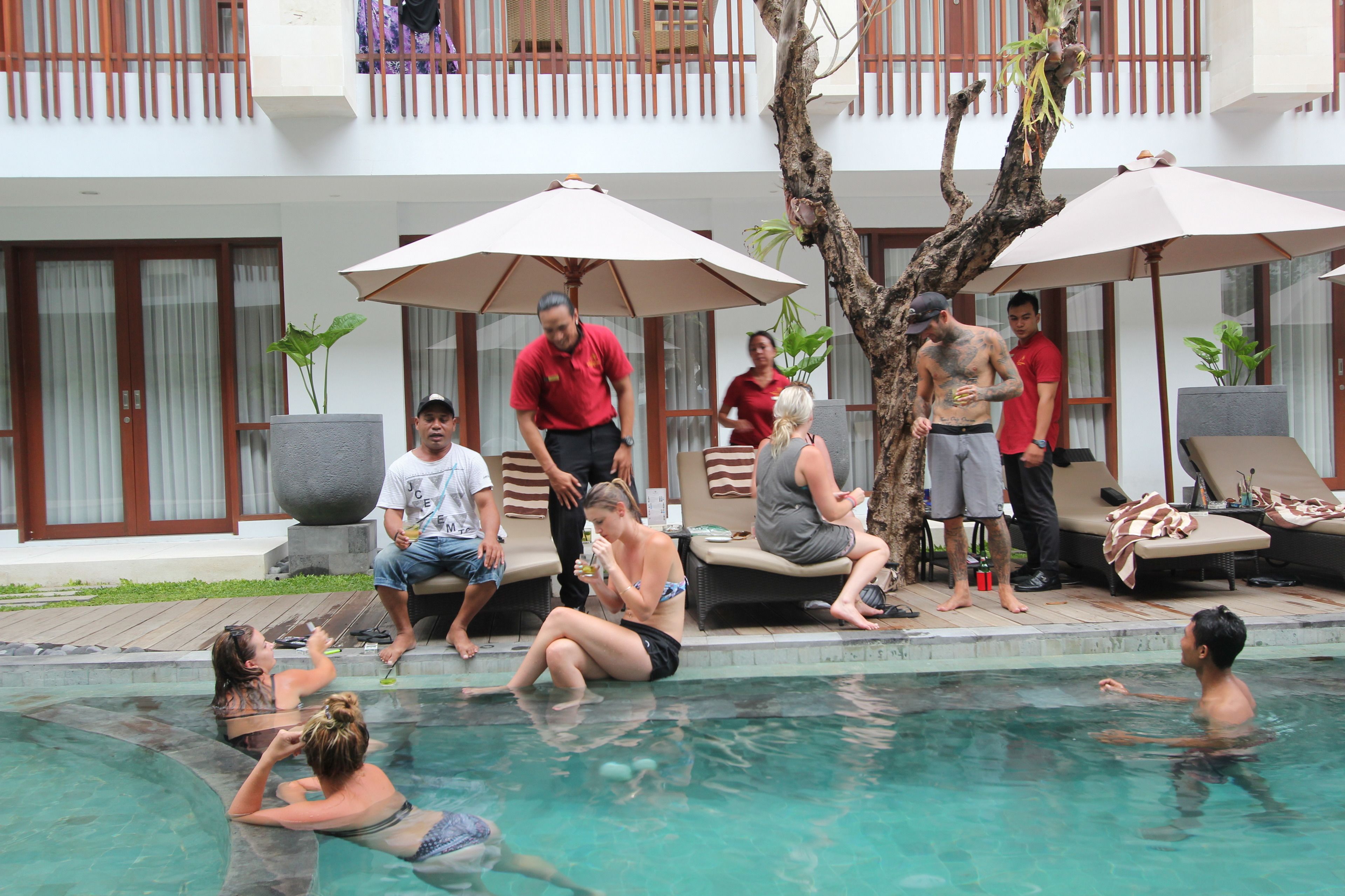 A poolside area with lounge chairs, umbrellas, and a pool.