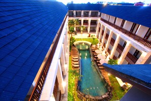 A multi-story hotel with a rooftop pool, balconies, and a well-lit courtyard. - Grand La Walon Hotel (Kuta)