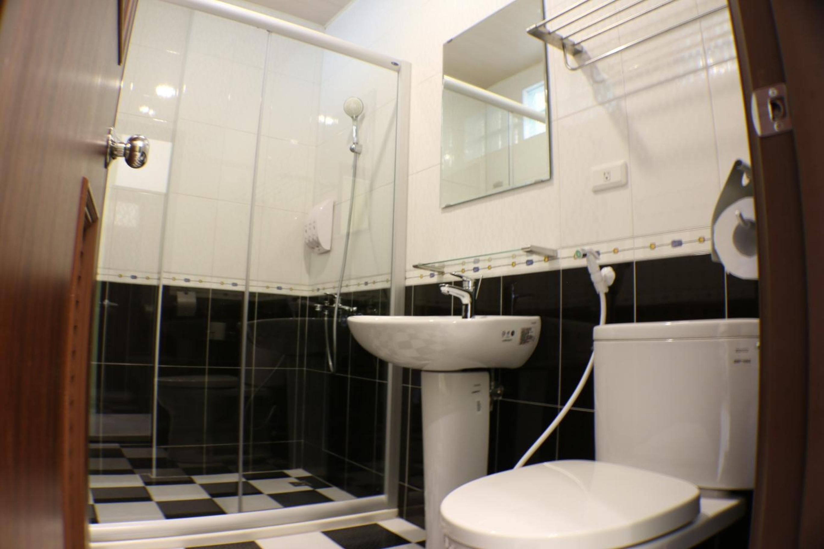 A bathroom with a shower, toilet, and sink.