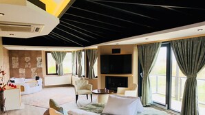 A modern hotel room with a large bed, a sofa, a TV, and a fireplace. - Velena Hotel (Sile)