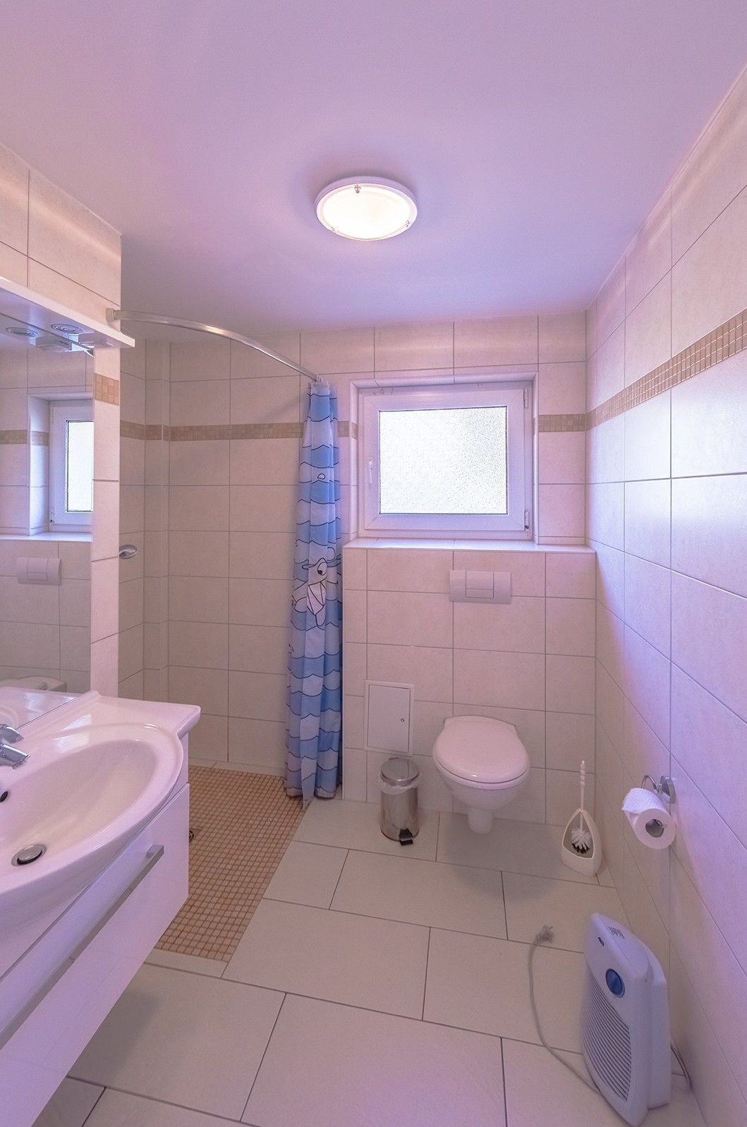 Ein Badezimmer mit Waschbecken, Toilette und Duschbereich.