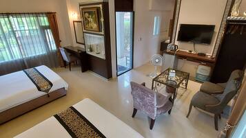 A hotel room with a bed, a desk, a chair, a TV, and a mirror.