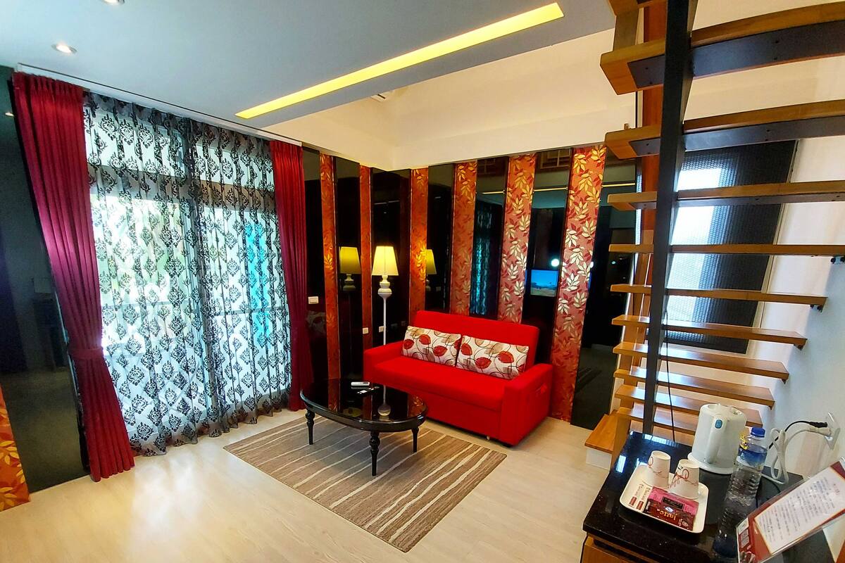 A modern living room with a red sofa, a round coffee table, and a TV.