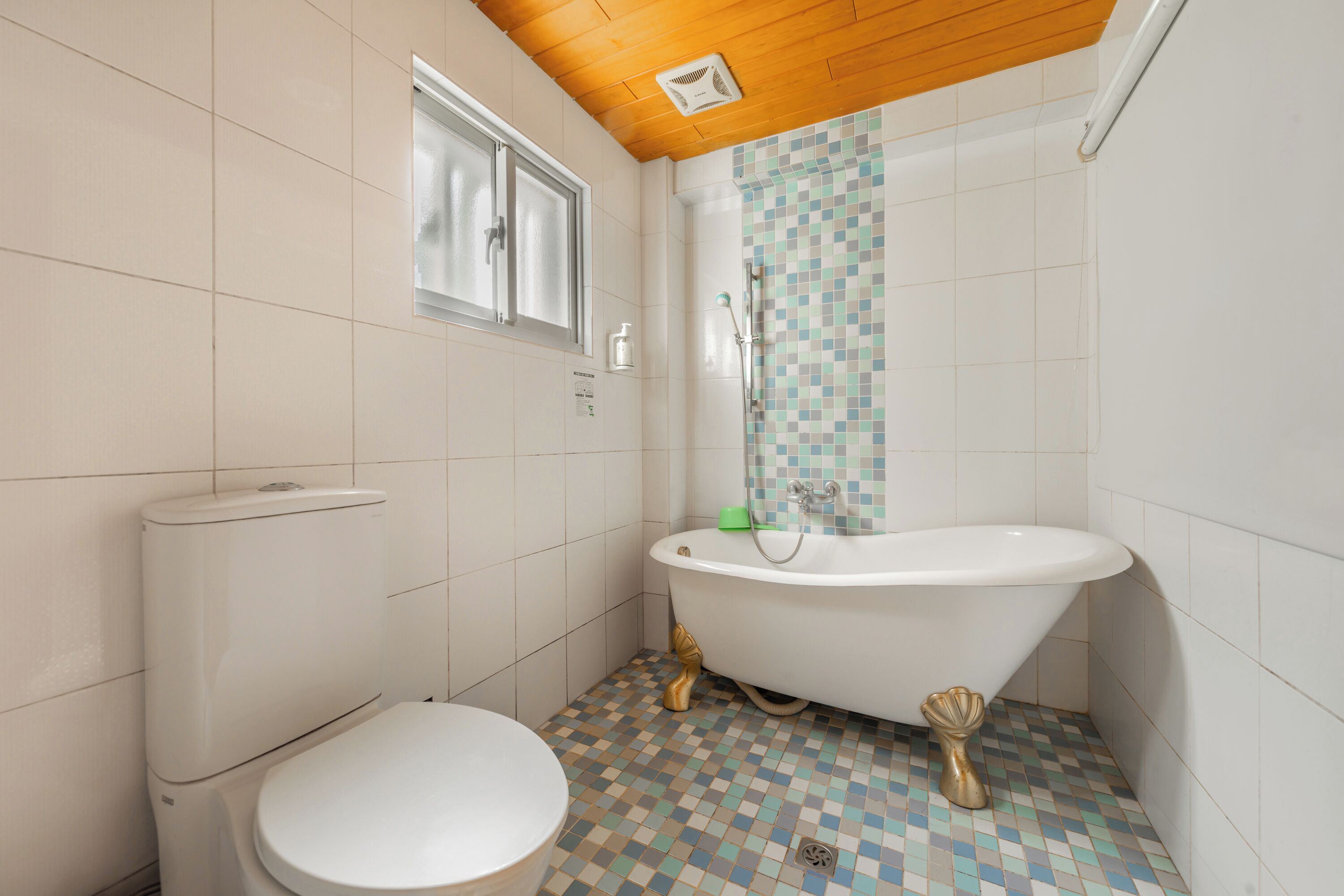 A bathroom with a toilet, a bathtub, and a shower.