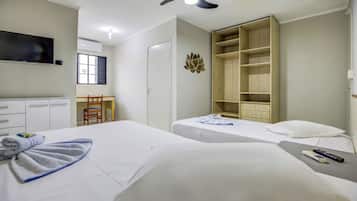 Habitación de hotel con dos camas, televisión, armario y escritorio con silla.