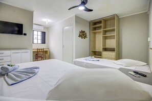 Une chambre d’hôtel avec deux lits, une télévision, une armoire et un bureau avec une chaise.
