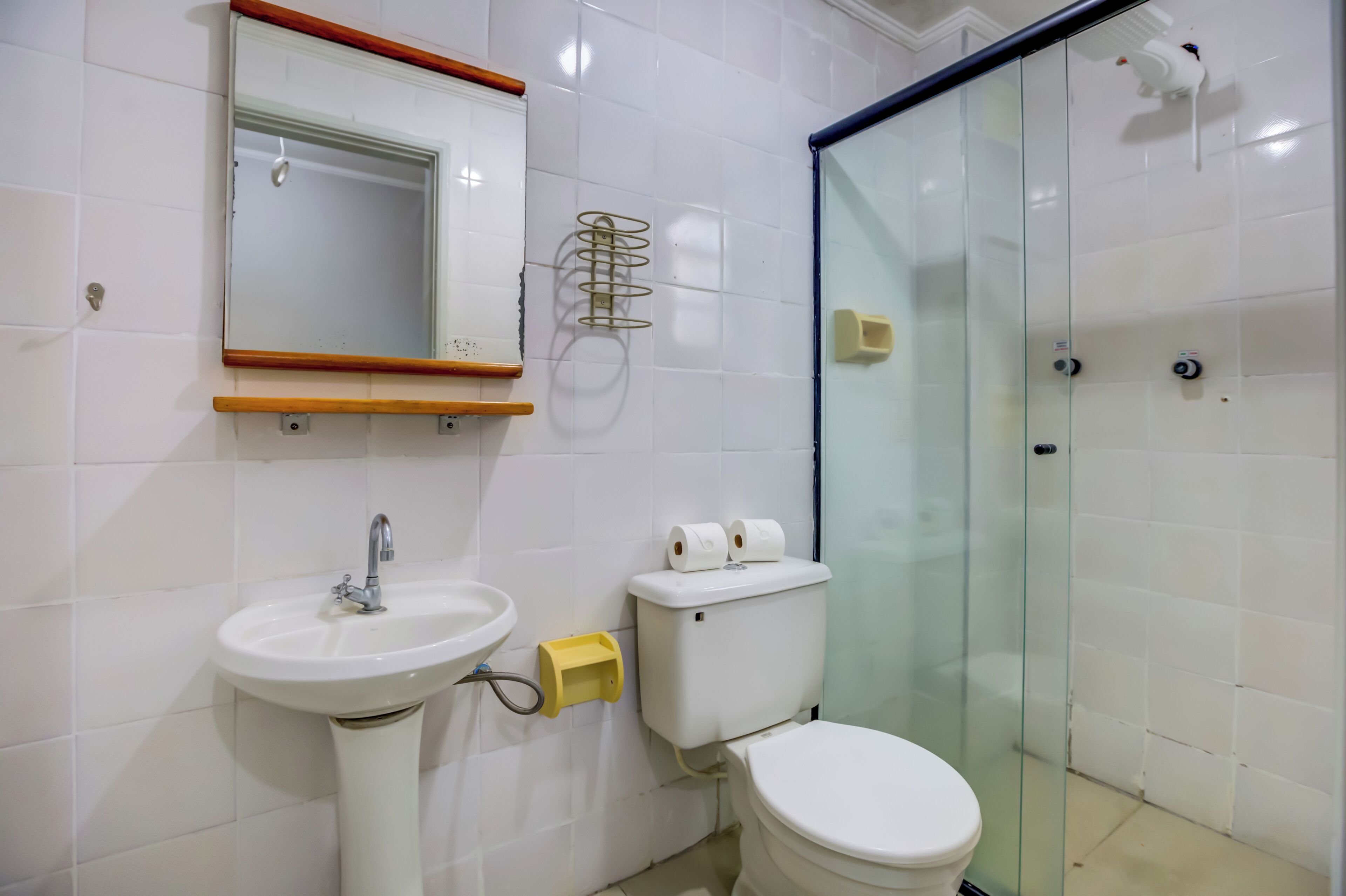 A bathroom with a white sink, a toilet, and a glass shower enclosure.