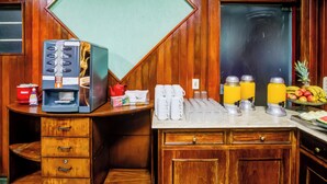 Eine Küchenzeile mit Kaffeemaschine, Obstschale und Kühlschrank.